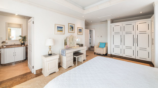View from the bed to the en-suite, dressing table and armchair at Smugglers Cove 3, holiday apartment in Barbados