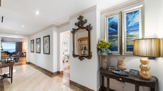 Smugglers Cove 3 hallway with an ornate mirror, twin seascape paintings and an amber lamp on a carved console, Barbados