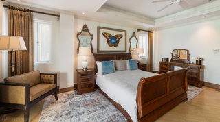 Dressing table with swing mirror and a buttoned settee in the sleigh-bed room at Smugglers Cove 3, Paynes Bay, Barbados