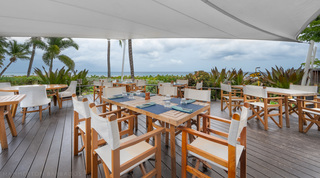 Resort restaurant deck under a sail shade facing the sea, for guests of St. Peter's Bay 104, a beach apartment in Barbados