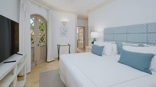 Aqua headboard bedroom with arched louvred doors and a glazed door beyond, St. Peter's Bay 104 in Barbados