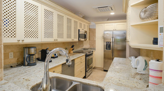 Kitchen with lattice cabinets, granite worktops and a stainless steel fridge at St. Peter's Bay 104, west coast Barbados