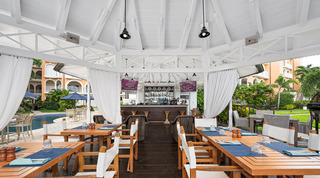 Resort bar pavilion with high stools and laid tables beside the communal pool, St. Peter's Bay 104 in Barbados