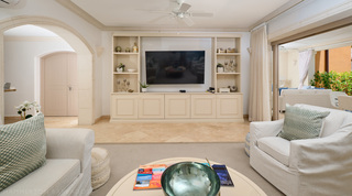Built-in shelving around the TV and an archway to the hall in the St. Peter's Bay 104 living room, Barbados