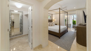 Dressing room with an antiqued mirror and hanging rail beside a four-poster bedroom, St. Peter's Bay 106 in Barbados