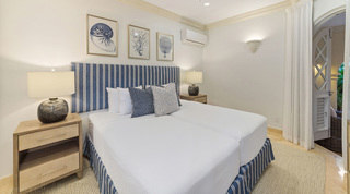 St. Peter's Bay 106 twin bedroom with nautilus, coral and sea fan prints above the striped headboard, Barbados