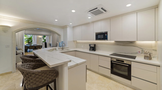 Kitchen with handleless white cabinets and veined worktops at St. Peter's Bay 106, holiday apartment in Barbados