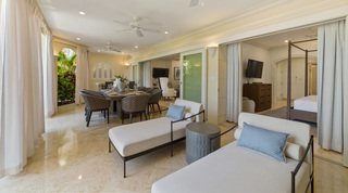 Two cream daybeds on the covered terrace, open to a four-poster bedroom, at St. Peter's Bay 106, apartment in Barbados