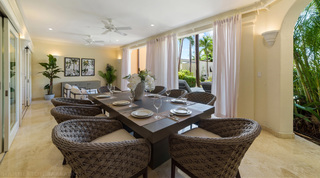 Sheer curtains frame garden palms beyond the dining terrace of St. Peter's Bay 106, holiday apartment in Barbados