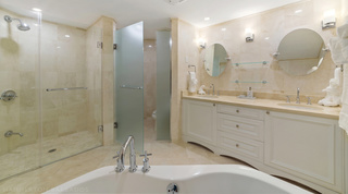 Glass shower, frosted door and twin-basin vanity seen over the bath at St. Peter's Bay 106, Barbados apartment rental