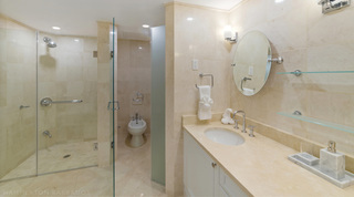 Glass-enclosed shower and single-basin vanity with a tilting round mirror in a St. Peter's Bay 106 bathroom, Barbados