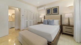 Bench at the foot of the bed, lattice wardrobe doors and a bathroom beyond, St. Peter's Bay 106, Barbados