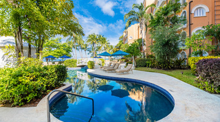 Communal resort pool with sun loungers and palms at St. Peter's Bay 111, holiday apartments Barbados
