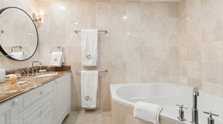 Ensuite with a corner bathtub and round black-framed mirror over the vanity, St. Peter's Bay 204, Barbados