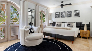 Twin beds made up as a king beneath four black and white photographs, a St. Peter's Bay 204 bedroom in Barbados