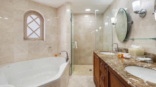 Corner tub under an arched lattice window and twin-basin wooden vanity, St. Peter's Bay 204 bathroom, Barbados