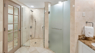 Glass walk-in shower with a mosaic floor in an ensuite at St. Peter's Bay 204, Barbados apartment rental