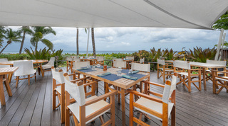Beachside restaurant with director's chairs under a shade sail, on site at St. Peter's Bay 204 in Barbados