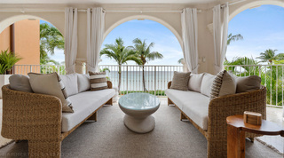 Arched sea-view terrace with facing woven sofas at St. Peter's Bay 204, a luxury apartment in Barbados