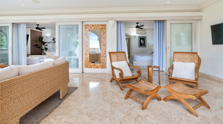 Woven sofa, planter's chairs and a wall-mounted TV on the terrace outside the living room, St. Peter's Bay 204, Barbados