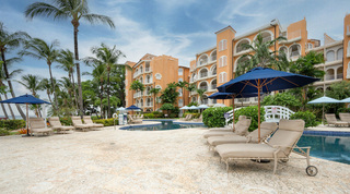 Navy parasols and a white footbridge over the communal pool at St. Peter's Bay 204, Barbados apartments