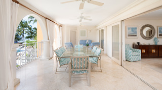 Covered terrace with a glass dining table and teal ikat chairs at St. Peter's Bay 207, holiday apartment in Barbados
