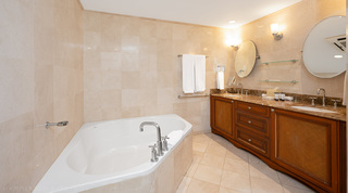 Bathroom with a corner soaking tub, double marble vanity and oval tilting mirrors at St. Peter's Bay 207 in Barbados