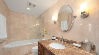 Shower over the bath and a brown marble vanity with oval mirror, St. Peter's Bay 207, Barbados apartment rental