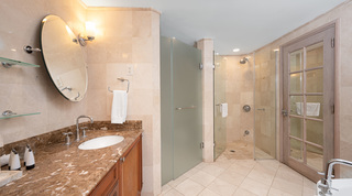 Walk-in glass shower beside a brown marble basin vanity and glazed door in a St. Peter's Bay 207 bathroom, Barbados