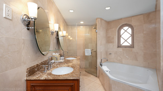 St. Peter's Bay 207 bathroom with twin marble basins, a glass shower and a bathtub under an arched lattice window, Barbados