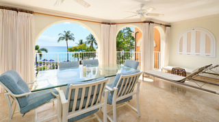 Candles and a glass hurricane on the six-seat terrace table, padded loungers alongside, St. Peter's Bay 308 in Barbados