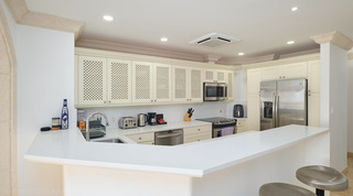 Angled peninsula, lattice cupboards and American-style fridge freezer at St. Peter's Bay 308, a Barbados apartment rental