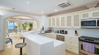 Silver stools at the white peninsula, a stainless cooker and the sea through an arch, St. Peter's Bay 308 in Barbados