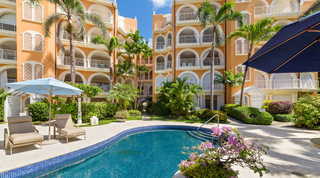 Pink bougainvillea by the communal pool steps, apricot blocks and palms beyond, St. Peter's Bay 308, apartments in Barbados
