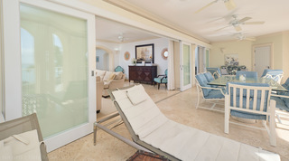 Tall-ship print and sunburst mirrors seen through open sliding glass doors from the terrace, St. Peter's Bay 308 in Barbados