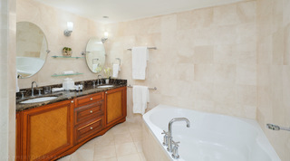 In a St. Peter's Bay 308 bathroom in Barbados, starfish and shells on a glass shelf between tilting mirrors over the basins