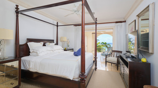 Four-poster bed, mirrored chest and silver-framed mirror, sea glimpsed beyond, St. Peter's Bay 308 on Barbados' west coast