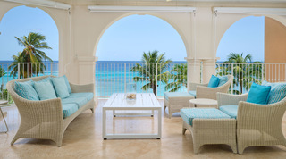 Woven sofa and armchairs with aqua striped cushions on the arched sea-view terrace of St. Peter's Bay 401, Barbados