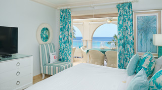 View from the bed past a cream-framed mirror to terrace dining and sea, St. Peter's Bay 401, apartments in Barbados