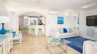 Archway to a breakfast bar with four lime-green stools at St. Peter's Bay 401, apartments in Barbados