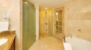 Tiled shower with a glass door between a frosted green glass door and a glazed wooden door at St. Peter's Bay 401, Barbados