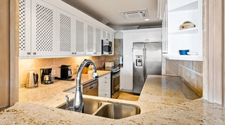 Double sink, American-style fridge freezer and cooker in the kitchen of St. Peter's Bay 404, holiday apartment in Barbados