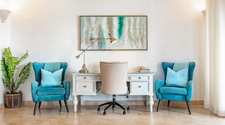 Writing desk with a glass top between teal wingback armchairs, St. Peter's Bay 404, apartments in Barbados