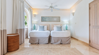 Twin beds with tufted headboards and turquoise glass lamps in a bedroom at St. Peter's Bay 404, Barbados apartments