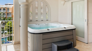 St. Peter's Bay 404 hot tub with steps under an arched lattice shutter, by a balcony over the communal pool, Barbados