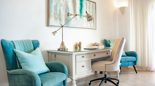 Swing-arm lamp and a studded desk chair at the white writing desk beside a teal armchair, St. Peter's Bay 404 in Barbados