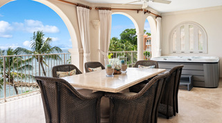 Terrace dining table with sand-filled hurricane vases beside the hot tub at St. Peter's Bay 404 in Barbados