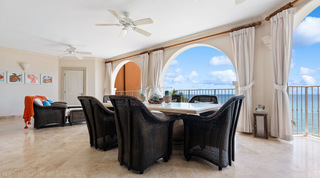St. Peter's Bay 404 terrace dining table facing the sea through white arches, with turtle and crab prints, Barbados