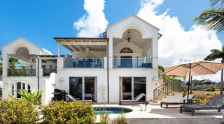 White gable and glass balconies rising over the plunge pool at Sugar Cane Ridge 1 – Sunset Views, luxury villa in Barbados