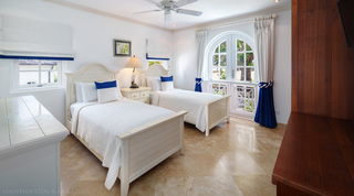 Twin bedroom with blue accents, an egret lamp and arched doors at Sugar Cane Ridge 2 – Coral Blu, a Barbados villa